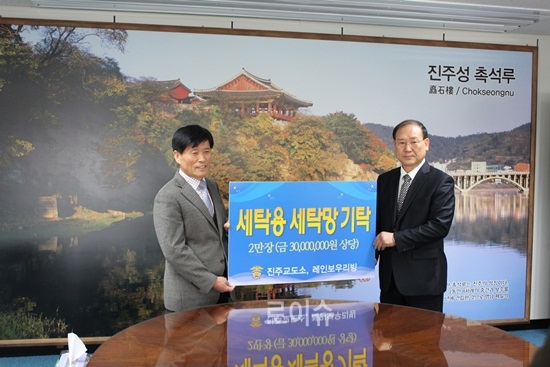 ▲진주교도소정동규소장(사진우측)이진주시에세탁망을기탁하고정영경부시장(사진왼쪽)과기념촬영.<진주교도소제공>