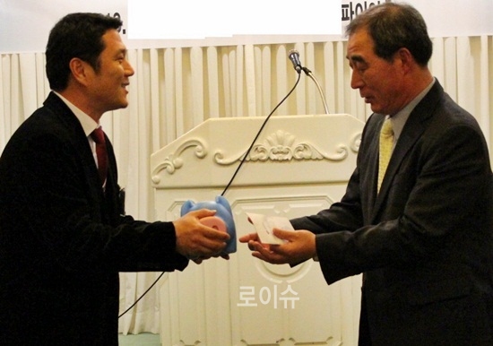 ▲우영준보호위원(사진왼쪽)이1년간모은돼지저금통을윤진화지부장에게전달하고있다.(사진제공=법무보호공단부산지부)