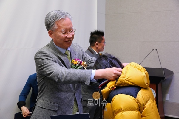 ▲강민구법원장이국제금융고창원분교졸업생에게졸업메달을걸어주며격려하고있다.(사진제공=창원지법)