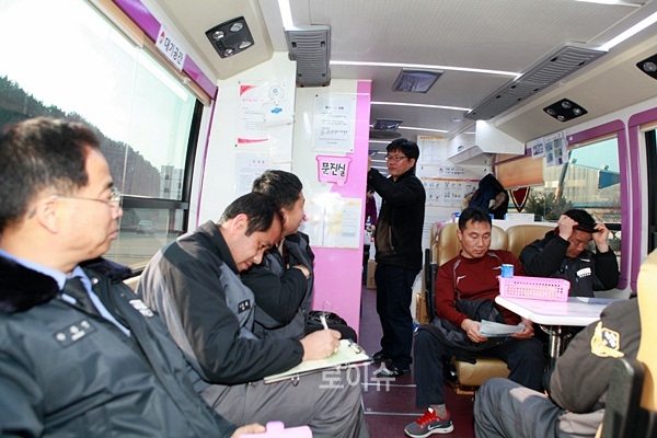 ▲헌혈대기중인직원들이문진표를작성하고있다.