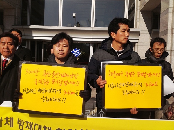 ▲방사선비상계획구역을30km로확대하라는피켓을내보이고있다.