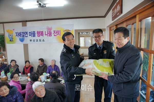 ▲자매결연마을독거노인과주민35명을초청해행복나눔잔치에서백미를전달하며위로하고있다.(사진제공=부산교도소)