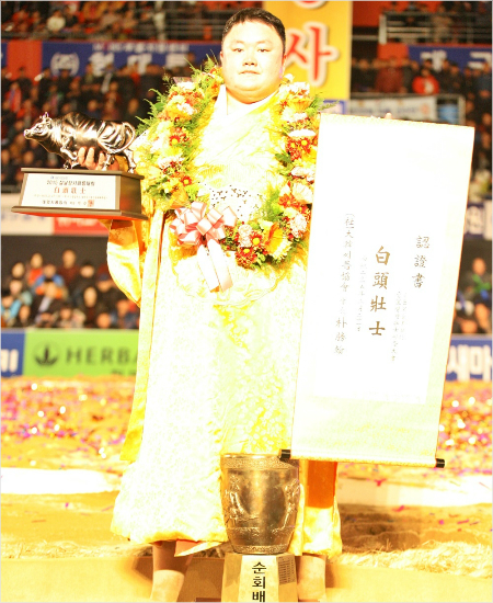 '명절이면나지'장성복이21일2015설날장사씨름대회백두급결승에서손명호를제치고장사에오른뒤트로피를들고포즈를취하고있다.(경산=대한씨름협회)