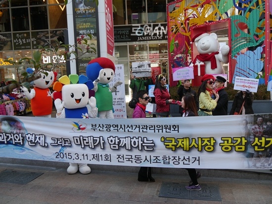 ▲과거와현재,그리고미래가함께하는“국제시장공감선거캠페인”플래카드를내걸고거리퍼레이드를펼치고있다.