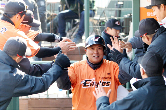 '난안당했지롱'한화김태균(가운데)역시지난주말LG와시범경기에서투수와상대하던중두발이타석밖으로나왔지만제재를받지는않았다.사진은7일적시타를때려낸뒤선수들과하이파이브를하는모습.(자료사진=한화)