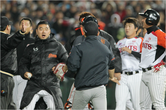 '그냥웃지요'롯데황재균(오른쪽)이12일사직한화전에서5회빈볼을맞고그라운드로나와웃음을지으며두팀선수들이벌이고있는그라운드대치상황을바라보는모습.(자료사진=롯데자이언츠)