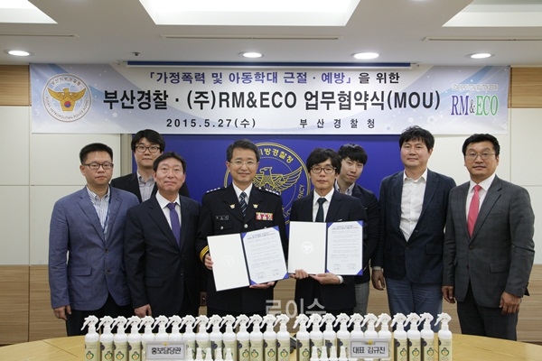 ▲부산경찰청홍보담당관인정석모총경과업체김규진대표등이업무협약서를내보이며기념촬영.(사진제공=부산경찰청)