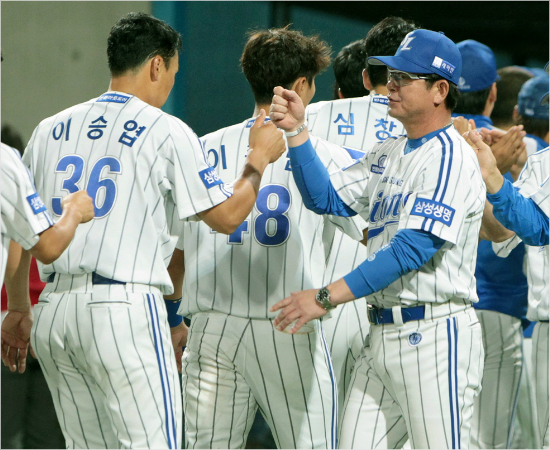 '이제1위뺏기면안돼'삼성류중일감독(오른쪽)이4일롯데와경기에서이긴뒤선수들과주먹을부딪히며격려하는모습.(포항=삼성)