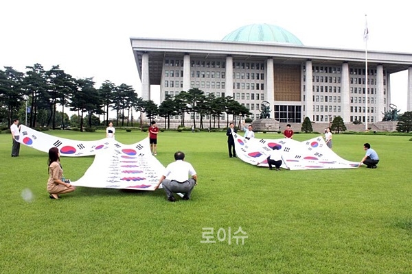 ▲숫자70모양으로만든광복70주년기념태극기를국회의사당잔디에펼치고있다.