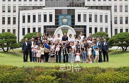 ▲동래구다문화가족들이윤인태법원장과부산법원청사를배경으로기념촬영을하고있다.(사진제공=부산고법)