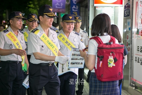 ▲권기선부산경찰청장이합동순찰을통해학생들에게홍보물은나눠주며소통하고있다.
