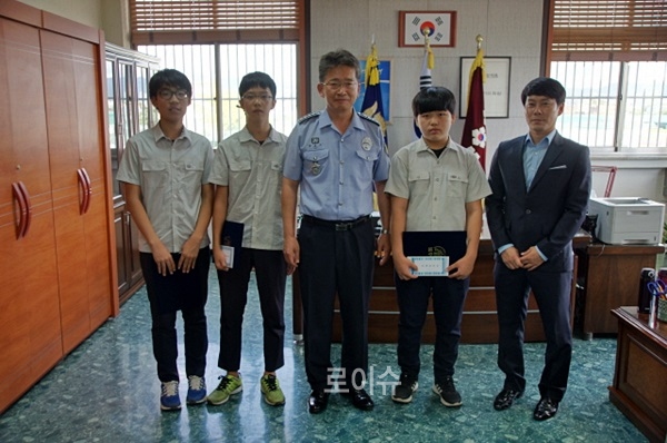 ▲박호서소장이낙동중학교학생들에게교정장학금을전달하고기념촬영.