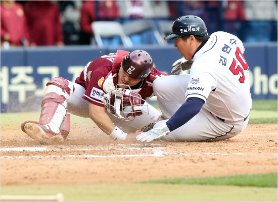 '비켜주세요'두산김현수가11일넥센과준플레이오프2차전에서2-2로맞선5회말오재원의외야뜬공때3루에서홈으로쇄도하다상대포수박동원과충돌하는모습.(자료사진=두산)