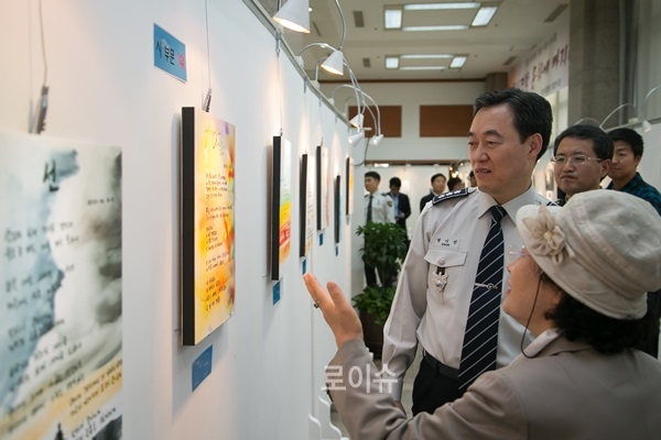▲권기선부산경찰청장이작품설명을듣고있다.(사진제공=부산경찰청)