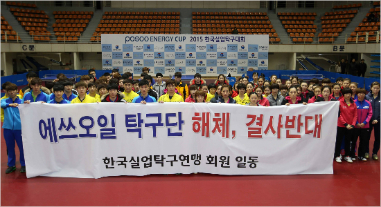 '살려주세요'한국실업탁구연맹선수들과지도자등회원들이27일포스코에너지컵한국실업탁구대회개막식뒤에쓰오일탁구단해체를반대하는플래카드를들고결의하고있다.(영주=한국실업탁구연맹)