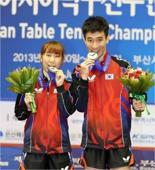 '나이런사람인데'박영숙(왼쪽)이지난2013년부산에서열린아시아선수권대회혼합복식에서우승한뒤이상수와함께금메달을깨무는모습.(자료사진=대한탁구협회)
