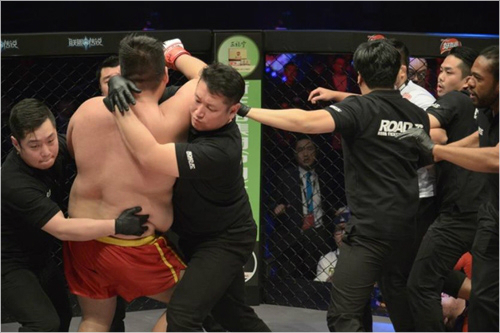 심판이경기중단을선언한후에도공격을멈추지않는아오르꺼러를심판들이말리고있다.사진=로드FC제공