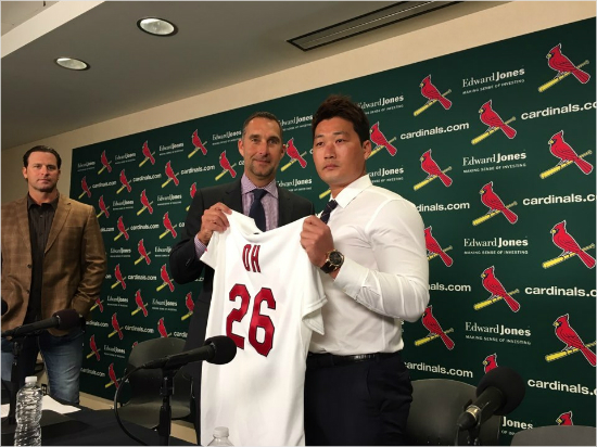 오승환(오른쪽)이12일(한국시각)세인트루이스입단기자회견에서마이크무시나감독(왼쪽)이지켜보는가운데존모젤리악단장과유니폼을들고포즈를취한모습.(사진=스포츠인텔리전스그룹)