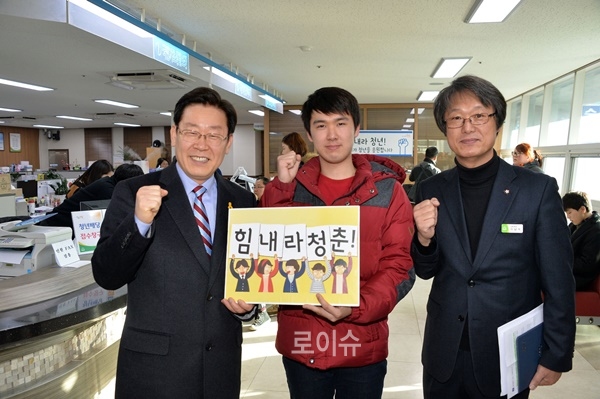 ▲이현민군이청년배당성남사랑상품권을받으려고주민센터를방문했다가깜짝방문한이재명성남시장(사진왼쪽)과기념촬영을하고있다.(사진제공=성남시)