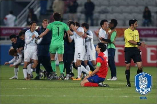 올림픽축구아시아최종예선결승에서일본선수들이극적으로우승한뒤기뻐하는가운데한국선수가망연자실한표정으로하늘을바라보는모습.(도하=대한축구협회)