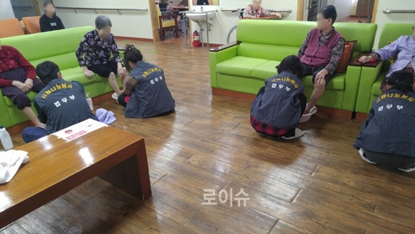 사회봉사명령대상자들이치매어르신의발을씻어주며자식노릇을하고있다.(사진제공=부산준법지원센터)