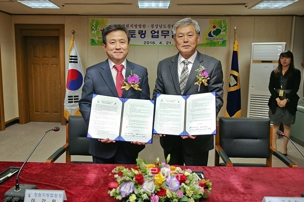 이강원창원지법원장(사진왼쪽)과안병학창원교육지원청교육장과업무협약서를내보이며기념촬영.