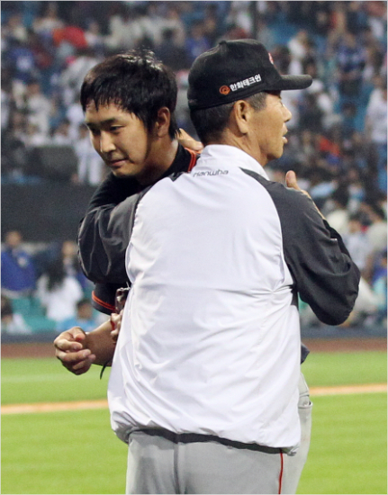 '자네가있어다행이야'한화김성근감독(오른쪽)이4일삼성과원정에서3이닝1실점호투로8-7승리를지켜낸심수창을껴안아주는모습.(대구=한화이글스)