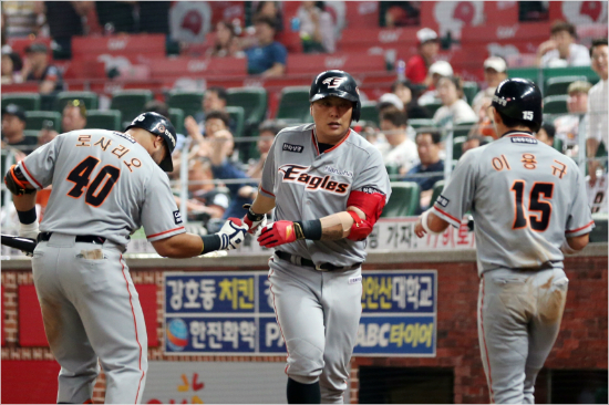 '김거포납시오'한화김태균(가운데)이7일SK와원정에서8회역전결승투런포를날린뒤로사리오,이용규등동료의축하를받는모습.(인천=한화)