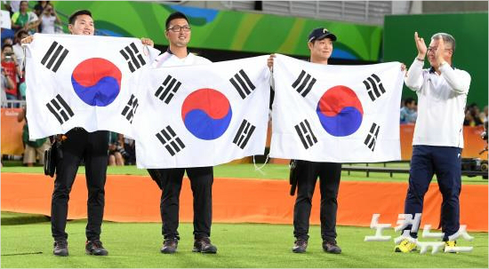 남자양궁단체전결승에서미국을꺾고금메달을획득한남자양궁대표구본찬(왼쪽부터)김우진이승윤,박채순감독이6일오후(현지시간)브라질리우데자네이루마라카낭삼보드로무경기장에서태극기를펼쳐들고기쁨을나누고있다.(리우=올림픽사진공동취재단)