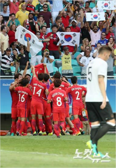올림픽축구대표팀선수들은황희찬의선제골이터지자대회직전부상으로올림픽출전이무산된송주훈의등번호4번이적힌유니폼을들고기뻐하는세리머니를선보였다.사우바도르(브라질)=올림픽사진공동취재단