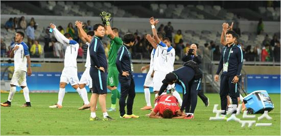 온두라스와한국의리우올림픽남자축구8강전이끝난뒤패배의아쉬움을눈몰로달래는손흥민의뒤로온두라스선수단이기뻐하며지나고있다.(올림픽사진공동취재단)