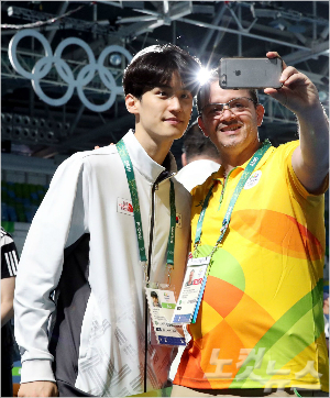 자원봉사자와기념촬영하고있는이대훈.18일밤첫경기에나선다(올림픽사진공동취재단).