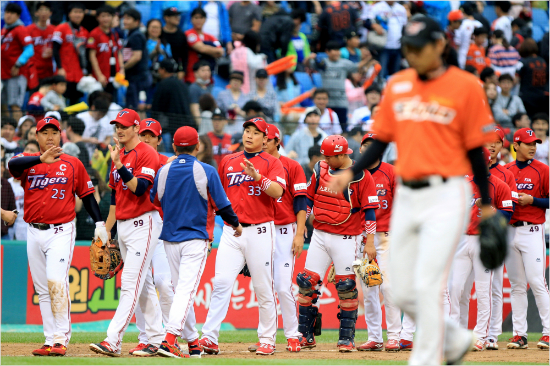 '희비교차'이범호(왼쪽부터),브렛필등KIA선수들이18일대전원정승리뒤하이파이브를하는사이한화선수가고개를숙이며그라운드를빠져나가고있는모습.(대전=KIA)