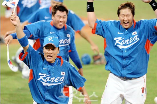 이승엽(왼쪽부터),류현진,이대호등야구대표선수들이쿠바와베이징올림픽야구결승전을3-2승리로이끌며금메달을거머쥔뒤태극기를손에들고감격하며그라운드를도는모습.(자료사진)