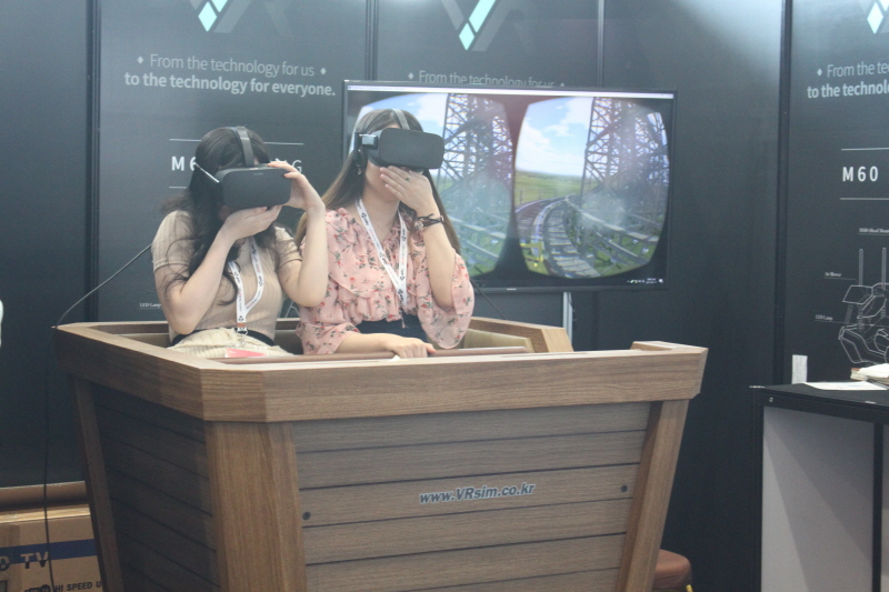 VR 롤러코스터를 타고 비명을 지르며 즐거워하는 여성들의 모습.