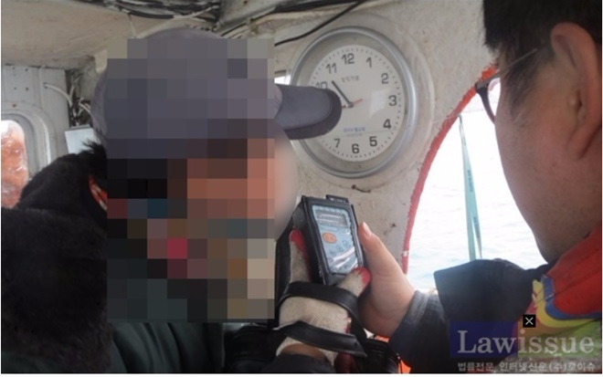 선장을 상대로 음주측정을 하고 있다.