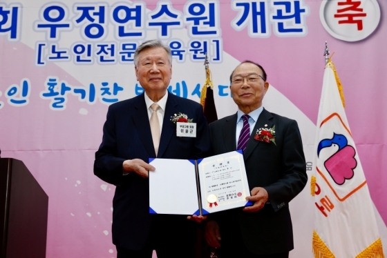 21일 전북 무주에서 '우정연수원' 개관식을 열고 이중근 부영그룹 회장(사진 왼쪽)이 이심 대한노인회 회장(사진 오른쪾)에게 기증서를 전달하고 있다. (사진=부영그룹)