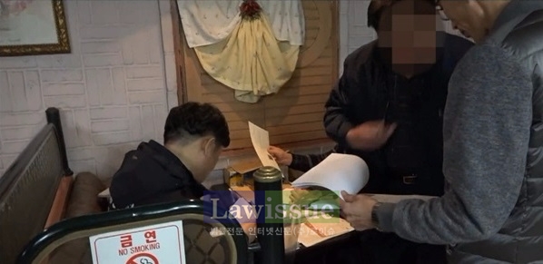 해경의 압수수색영장집행을 방해하고 있는 피의자.