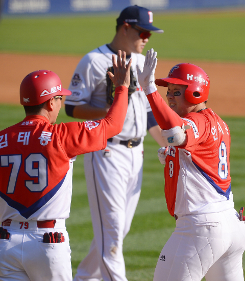 KIA 타이거즈 안치홍이 28일 잠실구장에서 열린 두산 베어스와 한국시리즈 3차전에서 4회초 2타점 적시타를 때린 뒤 김태룡 코치와 하이파이브를 하고 있다. (사진=KIA 제공)