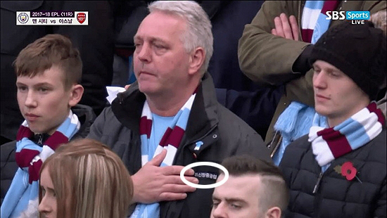 맨체스터 시티와 아스널의 경기 중 한 관중이 '신창중공업'이라고 적혀진 점퍼를 입고 있는 모습이 중계 화면에 잡혀 화제다. (사진=SBS스포츠 중계 화면 캡처)