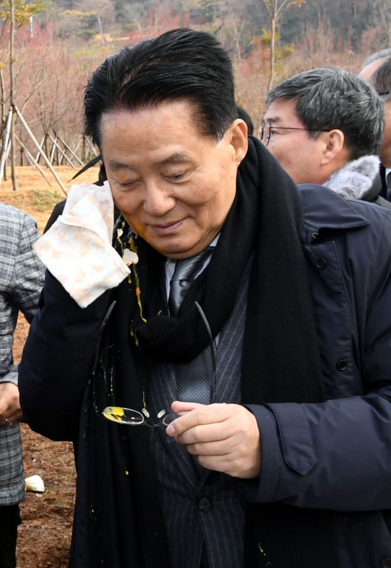 10일 오전 전남 목포시 김대중 노벨평화상 기념관 일원에서 열린 제1회 김대중 마라톤대회 출발 지점에서 박지원 국민의당 전 대표가 한 시민이 던진 계란을 맞고 얼굴을 닦고 있다.(사진=뉴시스)