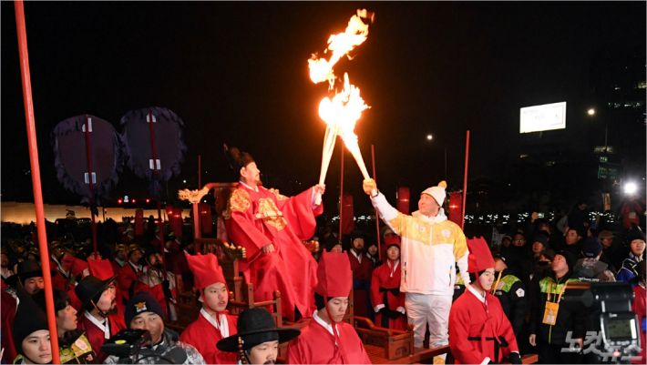 13일 오후 서울 광화문 앞에서 열린 ’2018 평창동계올림픽‘ 성화봉송 행사에서 황실문화회 종찬회 이홍배 이사장이 어가행렬로 성화봉송 후 봅슬레이·스켈레톤 선수 출신 강광배 한국체육대 교수에게 불꽃을 전달하고 있다. 황진환기자