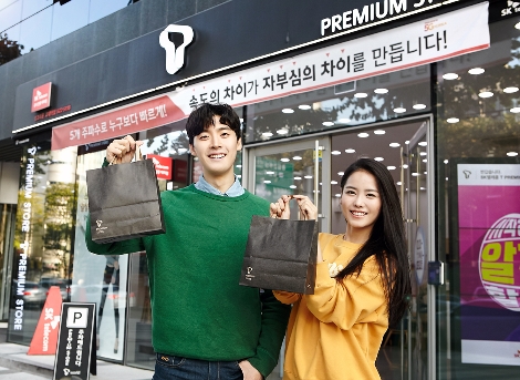 SK텔레콤 T월드 매장 앞에서 구매한 상품을 들어보이고 있는 고객의 모습. (사진=SK텔레콤)
