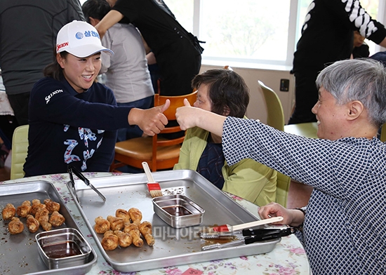 밀알재활원에서 진행한 치킨 소스 바르기 행사에서 장애우들과 함께 기뻐하는 김해림 사진제공-교촌F&B