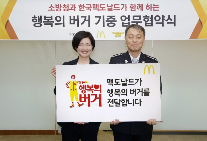 지난 23일 한국맥도날드 본사에서 열린 ‘소방청과 함께하는 행복의 버거 캠페인' 협약 체결식에서 조주연 한국맥도날드 사장(왼쪽), 조종묵 소방청장(오른쪽)이 협약서에 서명을 한 뒤 기념촬영을 하고 있다. (사진=맥도날드)