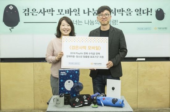 김아란 아름다운재단 나눔사업국장(왼쪽)과 허진영 펄어비스 COO가 '검은사막 모바일' 캐릭터 상품 판매금 전달식을 가진 뒤 기념 촬영을 하고 있다. (사진=펄어비스)
