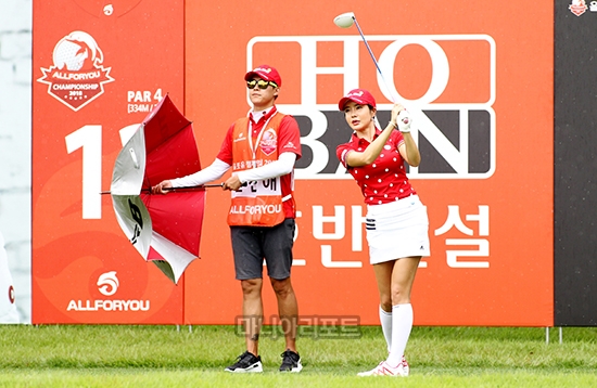 샷이 끝나자 우산부터 펼치는 캐디