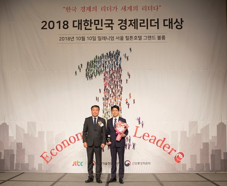 (사진=10일 ‘2018 대한민국 경제리더 대상’ 시상식에서 윤종기 이사장을 대신해 우진구 홍보처장(오르쪽)이 대리 수상 후 기념촬영을 하고 있다.)