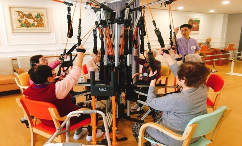 (사진=주식회사 더드림에서 운영하는 시니어데이케어센터에서 어르신들이 '바디스파이더' 기구를 체험하고 있다)