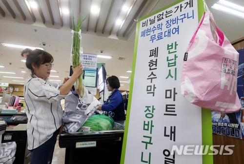 서울 강서구는 폐비닐 수거 대란속 폐현수막을 재활용해 만든 장바구니를 무료로 대여해 주는 '비닐 없는 가게' 운영을 24일 시작했다. 24일 오후 '비닐 없는 가게' 1호점인 서울 강서구 하나로마트 가양점에서 고객이 폐현수막으로 만든 장바구니에 구매한 물품을 담고 있다. 사진=뉴시스